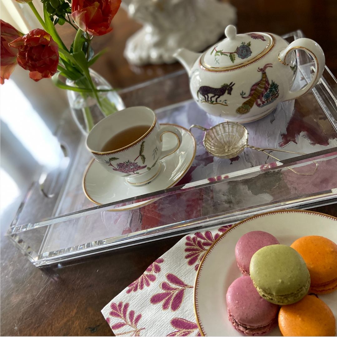 Tea pot and tea cup and an assortment of macarons